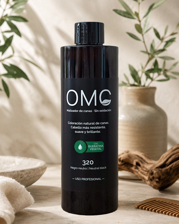 Bodegón con una botella de OMC, matizador de canas para uso profesional en salones de peluquería